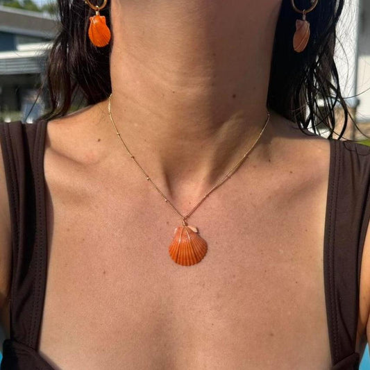 Coastal Ember shell necklace and matching earrings worn in sunlight