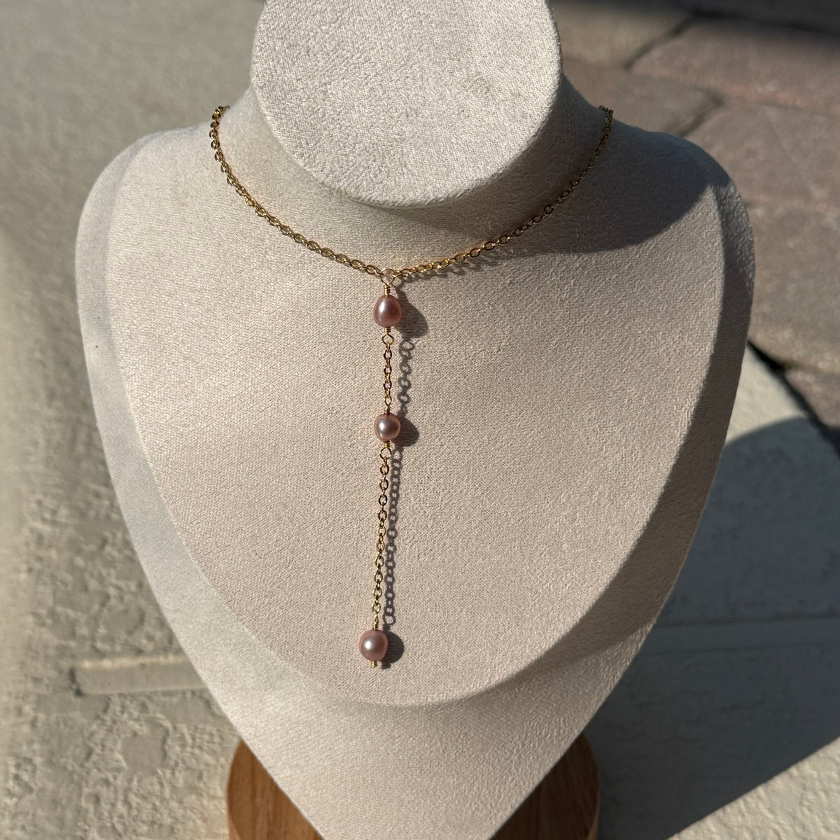 Blush Tide Pearl Lariat Necklace displayed on an ivory jewelry bust