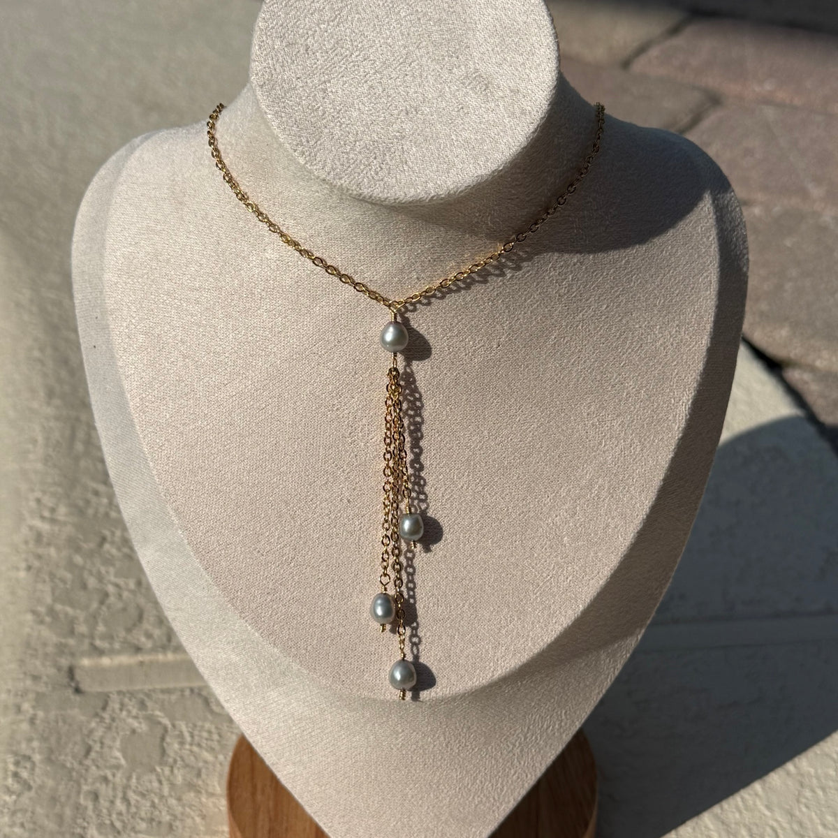 Sea Pearl Tassel Necklace displayed on an ivory jewelry bust