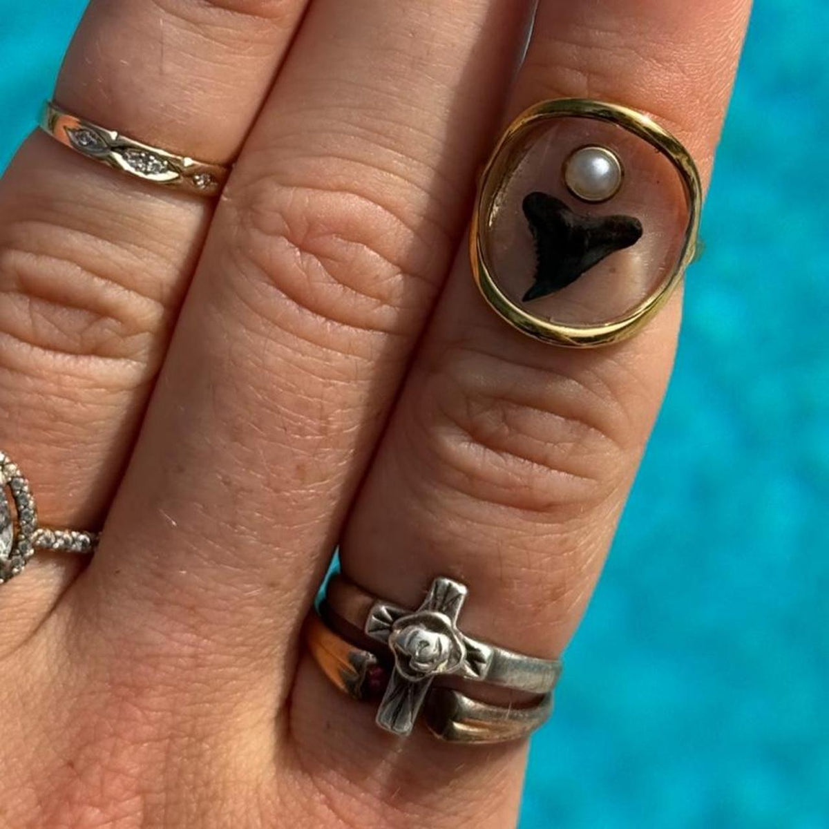 Gold shark tooth and pearl resin statement ring worn on hand