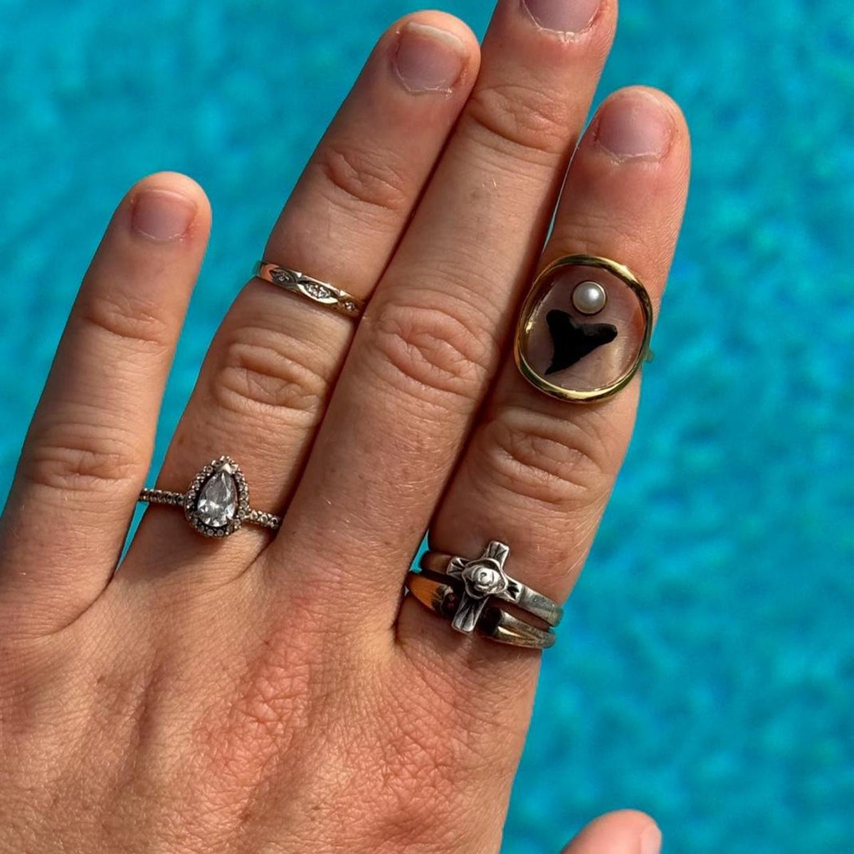 Gold shark tooth and pearl statement ring worn by pool