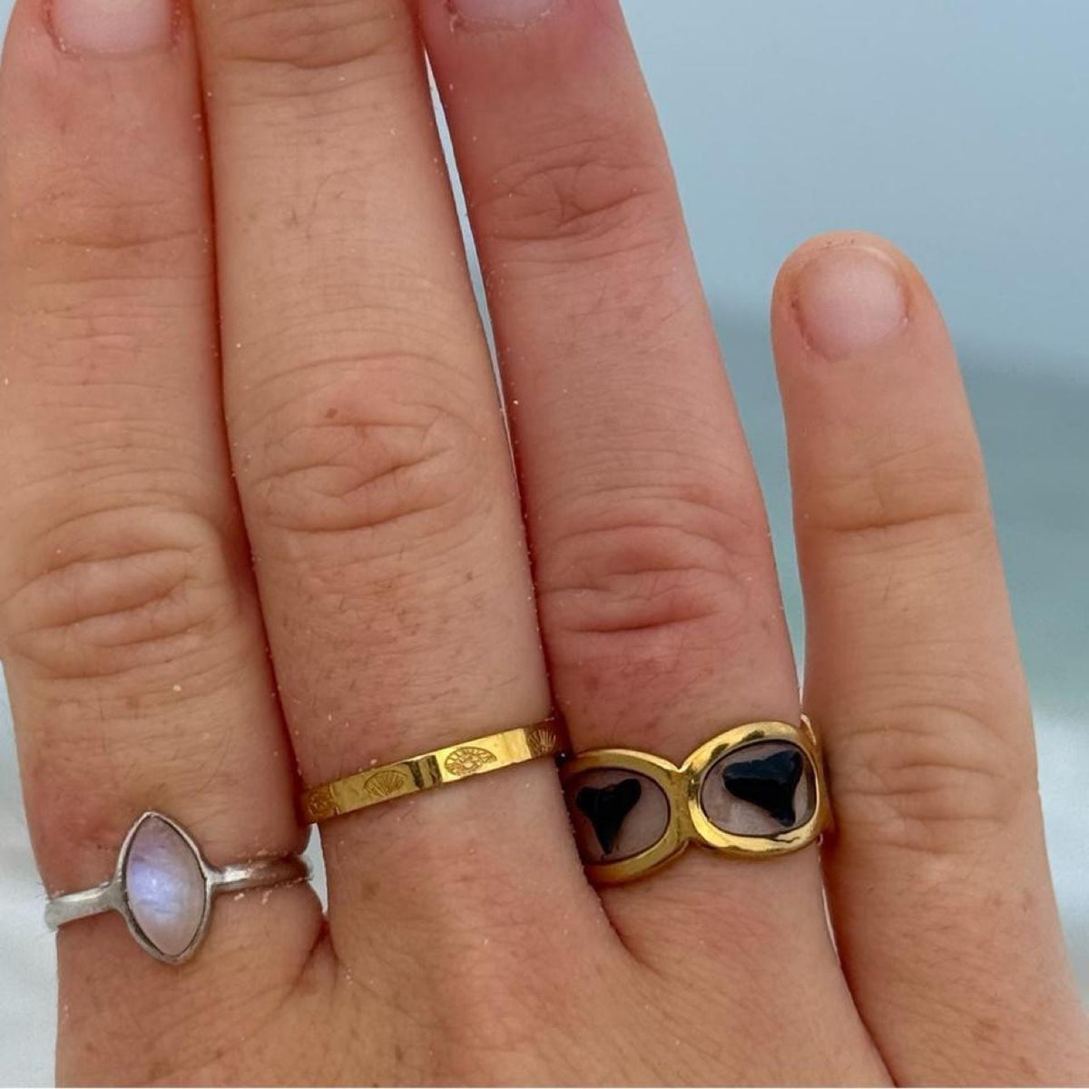 Gold shark tooth band ring worn on hand