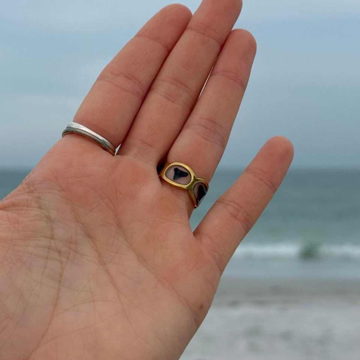 Shark tooth resin band ring worn by the ocean