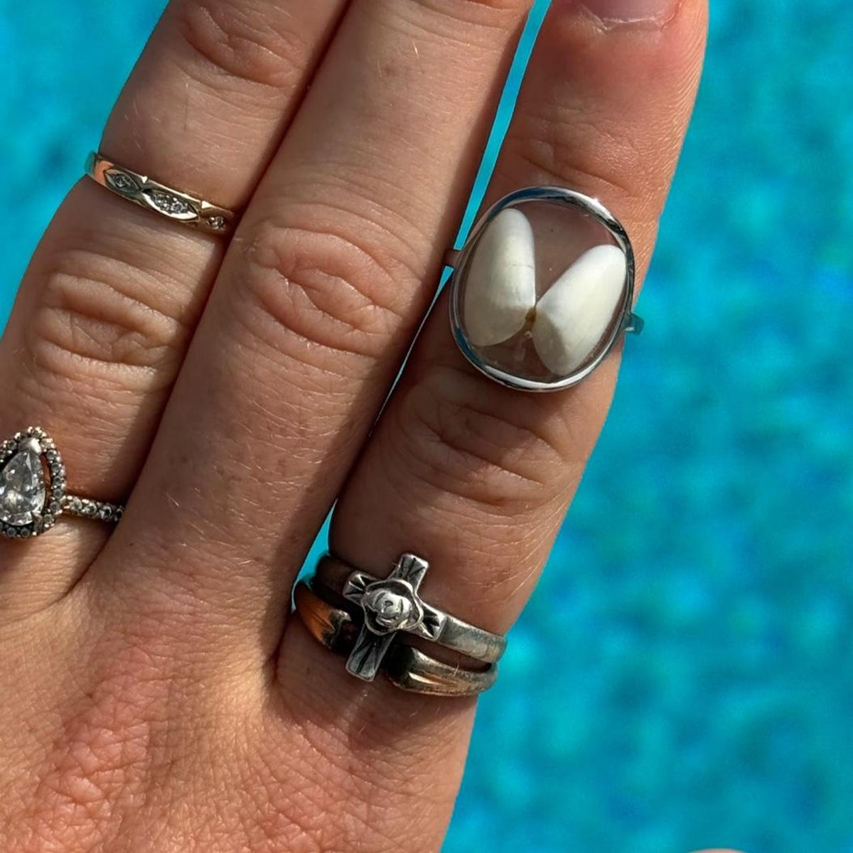Silver white butterfly resin ring styled by blue water