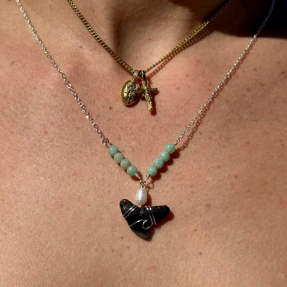 Close worn view of shark tooth and freshwater pearl necklace