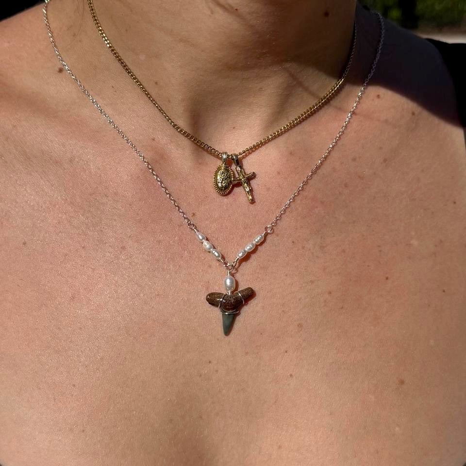 Close worn view of pearl and shark tooth necklace