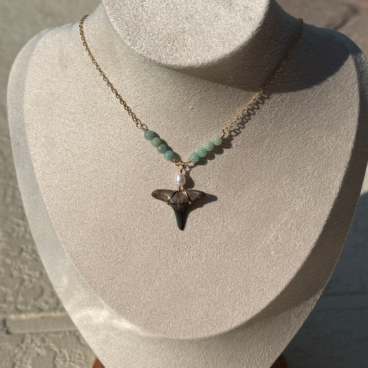 Close view of gold-tone shark tooth necklace