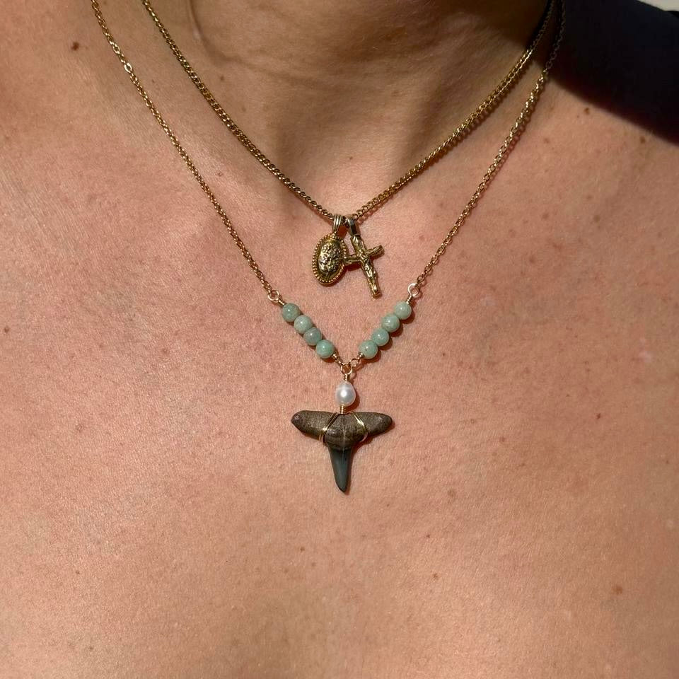 Close worn view of seafoam bead shark tooth necklace