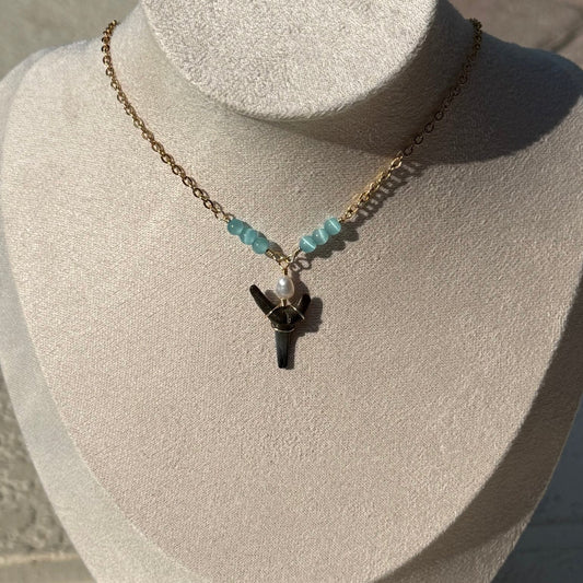 Blue Current Shark Tooth Necklace displayed on a jewelry bust