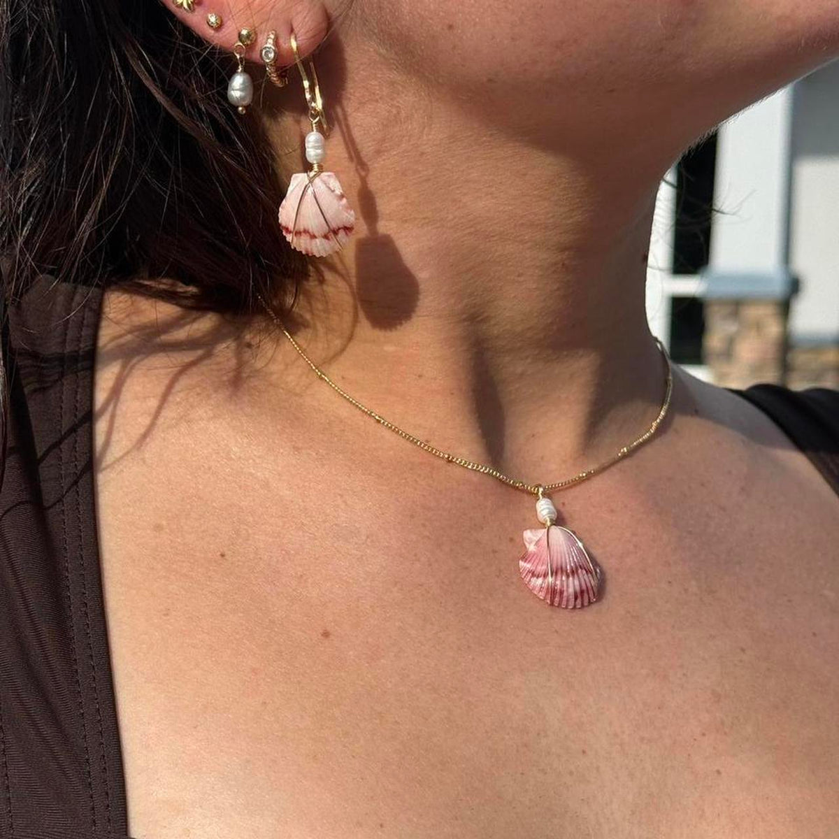 Rosewater scallop shell jewelry set in warm sunlight