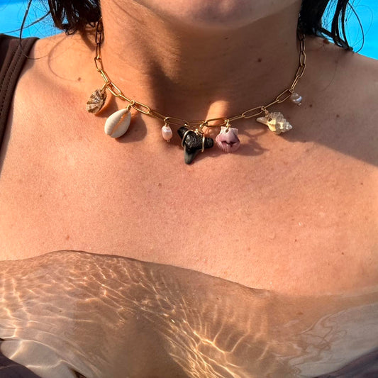 Handmade coastal charm necklace beside pool